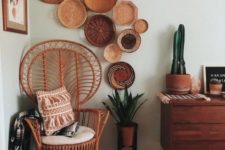 08 a small peacock chair with a white cushion, printed pillows and decorative plates on the wall over it