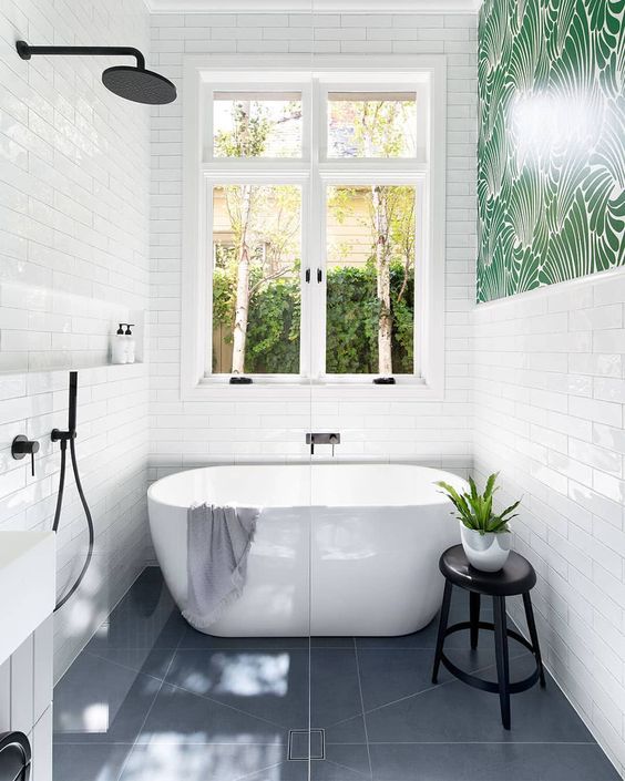 a bold contemporary bathroom with white skinny tiles, grey tiles on the floor and black hardware