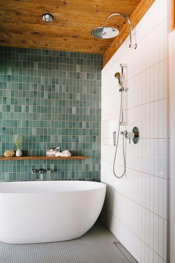 a bold contemproary bathroom with skinny white and mismatching green skinny tiles plus a grey mosaic tile floor