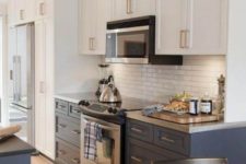 10 a two tone kitchen in navy and white with a white skinny tile backsplash and metal countertops for a bright and chic look