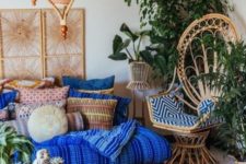 11 a peacock chair styled with a flat printed cushion in blue adds a bright touch to the space and matches the bedding