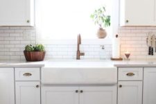 11 a white modern farmhouse kitchen with white skinny tiles and black grout on the backsplash and copper touches here and there