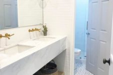 14 a chic modern farmhouse bathroom with white skinny tiles and a mosaic floor is a stylish space with an eye-catchy touch