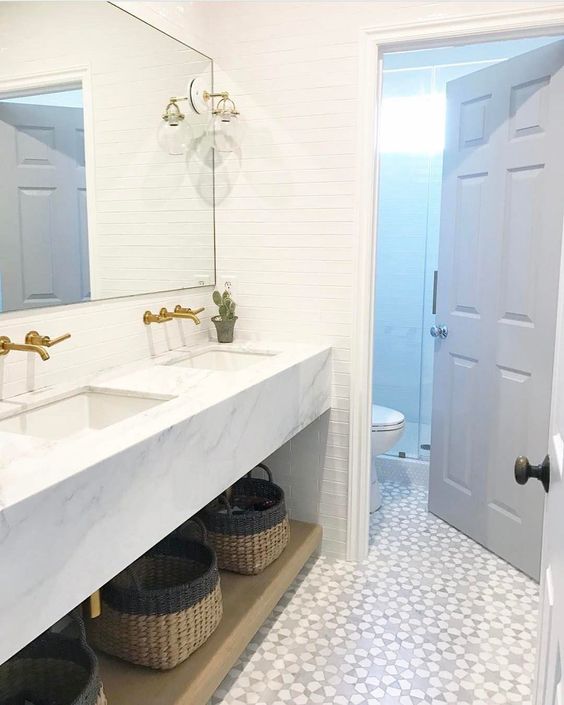 a chic modern farmhouse bathroom with white skinny tiles and a mosaic floor is a stylish space with an eye-catchy touch