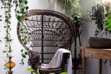 14 a dark stained peacock chair in a nook with potted greenery, a wodoen table and a Moroccan decoration for a boho feel