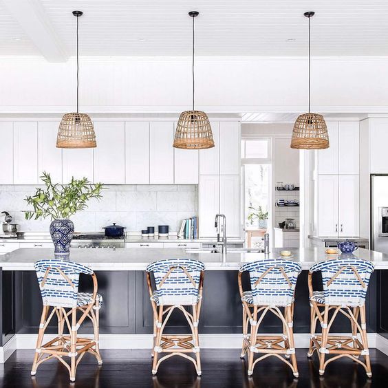 rattan stools with blue and white chair covers highlight the nautical design of the kitchen