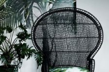 20 a simplified black peacock chair with bright printed pillows that add touch and freshness to it