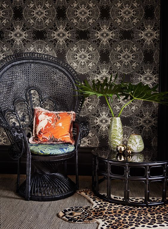 a super elegant black peacock chair with a bright pillow and cushion, a matching coffee table and a faux animal skin