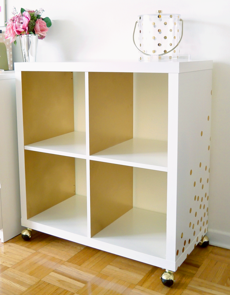 an IKEA Kallax shelf on casters, with gold polka dot decals and a matching jar becomes a gorgeous bar cart