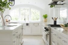 23 a neutral kitchen with a large arched window that floods the space with light and makes it more chic