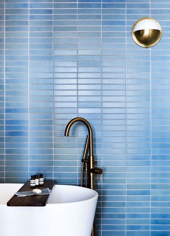 refresh your contemporary bathroom with laconic blue skinny tiles on the wall accented with white grout