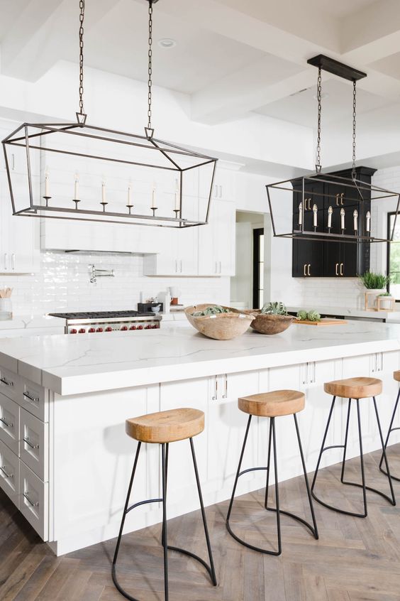 wooden kitchen stools with black metal legs add texture to the space and warm up the white interior a bit