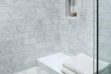 a Carrara marble shower space with a floating bench and nches in the wall is a chic and bright idea