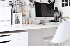 a Scandinavian home office done in mostly white, with a black noteboard and some more touches for an accent