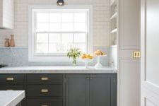 a graphite grey kitchen with neutral stone countertops and neutral upper cabinets plus elegant brass hardware