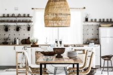 a neutral boho tropical kitchen with mosaic tiles, a wicker lamp, rattan chairs and a printed boho rug