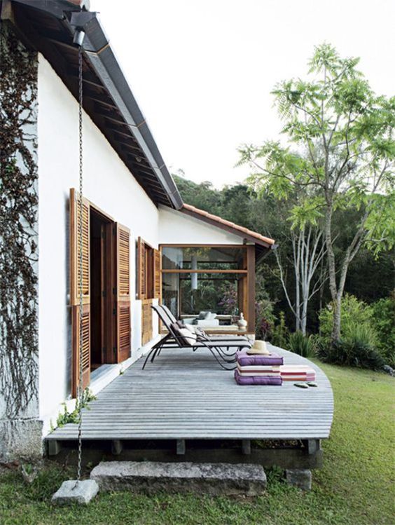 a small and comfy deck with loungers, pillows and cushions of various colors that add a lively touch