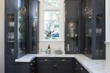 a small black vintage kitchen with white stone countertops looks rather formal, refined and very elegant