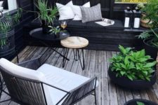 a small boho-inspired black and white deck with modern furniture, pillows, potted greenery to refresh the space