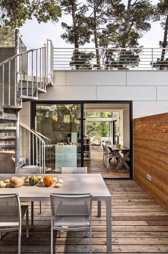 a small deck with a dining zone - simple metal furniture for dining and pumpkins as a table runner