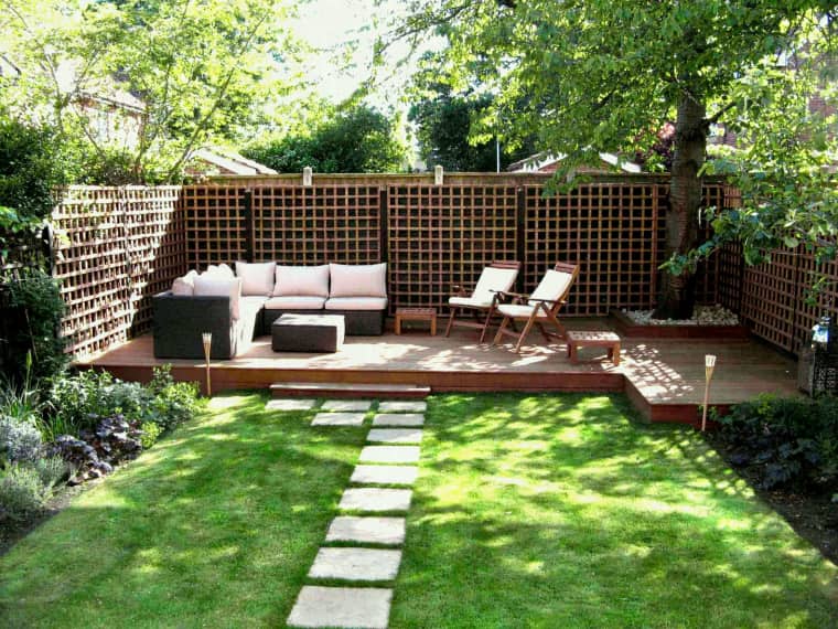 a small deck with contemporary furniture   a sofa, a coffee table, some folding chairs and stools around