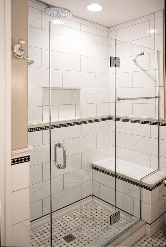 a stylish monochromatic shower space done with a built-in bench and a mosaic floor