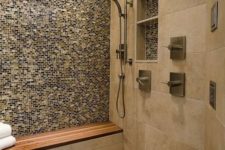 a welcoming earthy shower with various types of tiles that match, a teak floor and a built-in bench with a teak seat