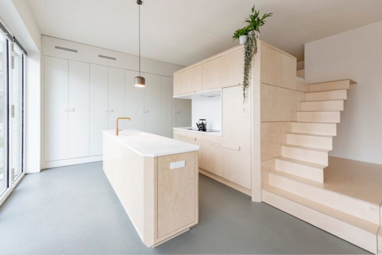 The kitchen island matches the storage unit and loft bed area creating a cohesive space with a modern feel The kitchen island matches the storage unit and loft bed area creating a cohesive space with a modern feel