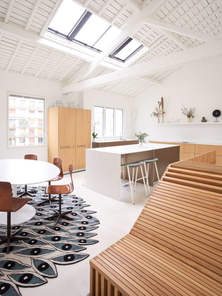 kitchen with a island that features seating options The kitchen features light-stained lower cabinets, a white kitchen island with a sitting space