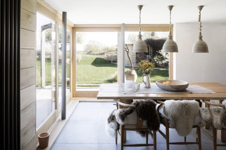 The dining zone features a wooden table, wishbone chairs, creative pendant lamps to highlight the zone The dining zone features a wooden table, wishbone chairs, creative pendant lamps to highlight the zone