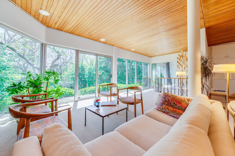 The second living room area features elegant chairs and a blush sofa, it's centered around the views