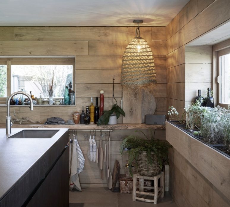 wooden kitchen design The kitchen is clad with light-colored wood, a wicker lamp, a basket planter and a metal kitchen island