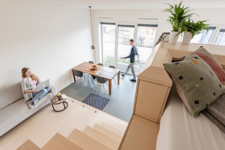 platform is a great way to save some space There's also a small sitting space with a grey sofa on a platform, which is lower than the sleeping space