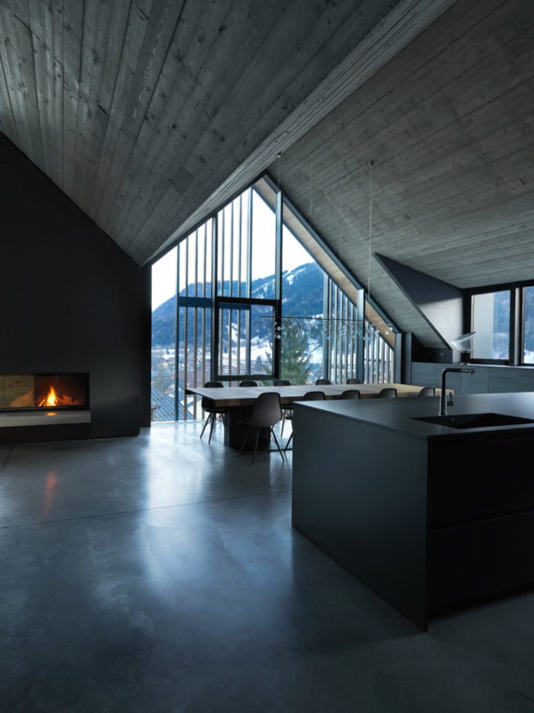 The kitchen is minimalis, done with a sleek black kitchen island and a stylish dining space centered in front of the window The kitchen is minimalis, done with a sleek black kitchen island and a stylish dining space centered in front of the window