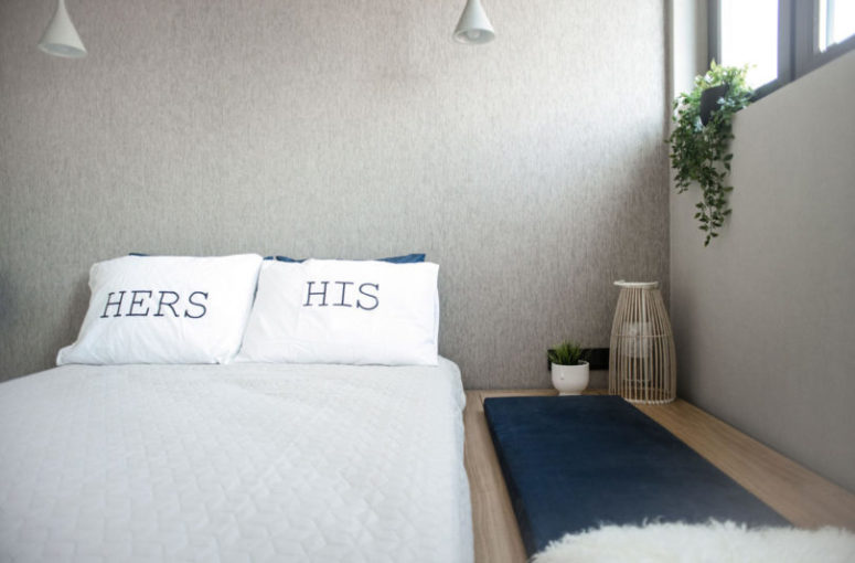 The master bedroom features a platform bed, wall lamps and faux fur