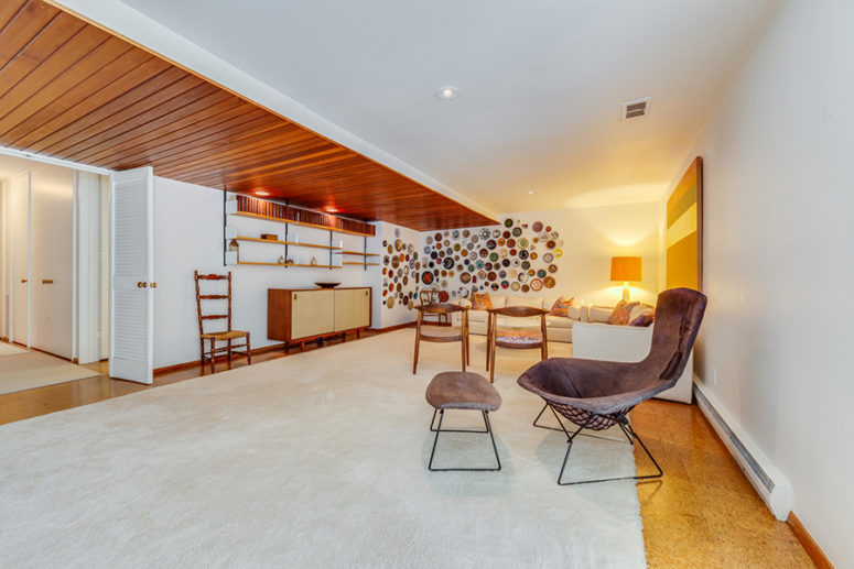 The third living area is done with lots of elegant mid century modern furniture and a wall with decorative plates The third living area is done with lots of elegant mid-century modern furniture and a wall with decorative plates