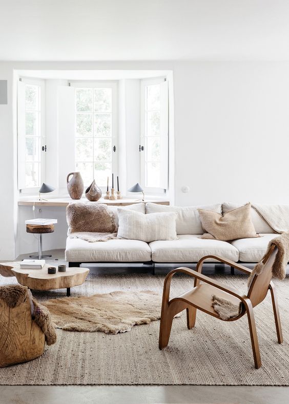 a large and comfy sofa placed in front of the window doesn't prevent light incoming and a windowsill provides some storage space