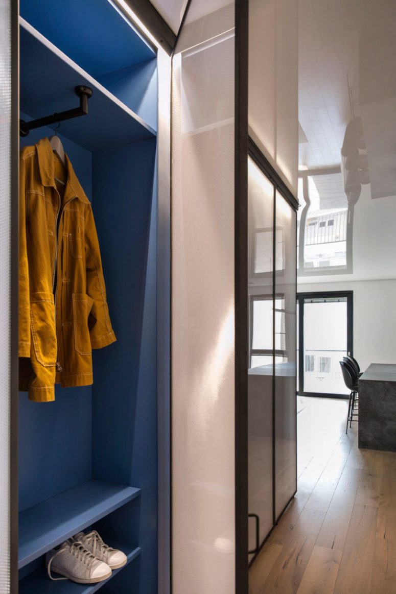 The entryway is done with an open blue storage unit with sliding doors, another its side is in the bedroom