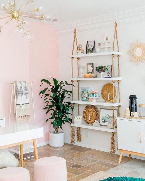 a hanging shelving unit with white shelves and simple ropes with long fringe add a boho feel to the glam space