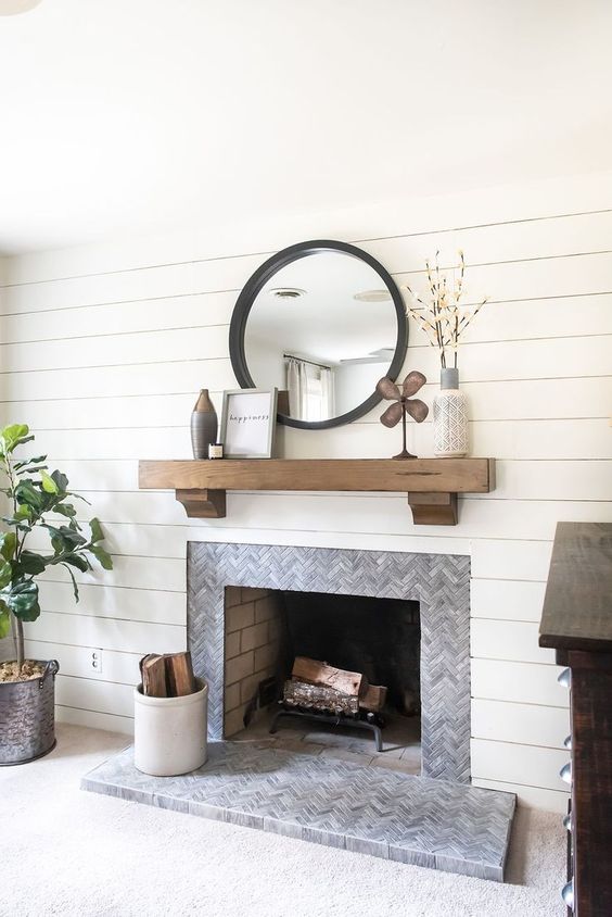 grey marble tiles clad in a chevron pattern and extended to the floor to highlight the fireplace area