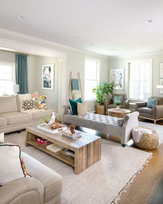 a neutral family room with an elegant backless sofa and chic neutral furniture around seems floating into another area