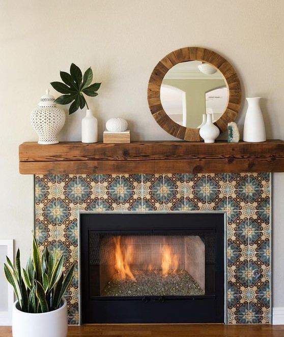 a built-in fireplace clad with colored patterned tiles around, with a rich stained wooden slab mantel