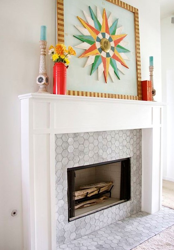 a built-in fireplace with marble hex tiles around it and on the floor and a stylish white frame and mantel