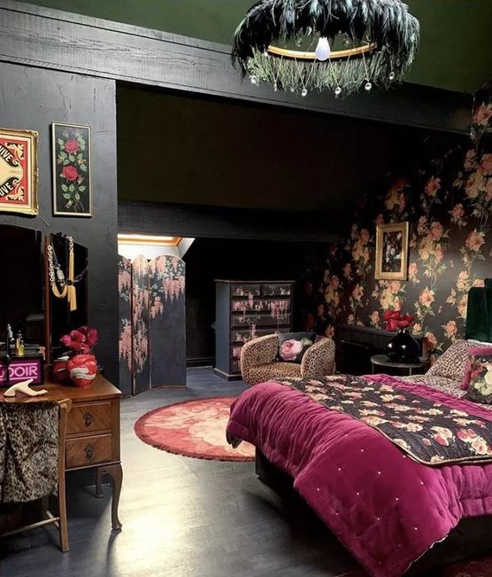 a chic eclectic bedroom with black walls and a black floral one, a bed with purple and floral bedding, a vintage vanity, a feather chandelier and some art
