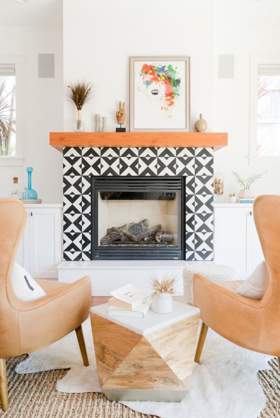 a faux fireplace with black and white graphic tiles clad around and a rich-stained wooden mantel