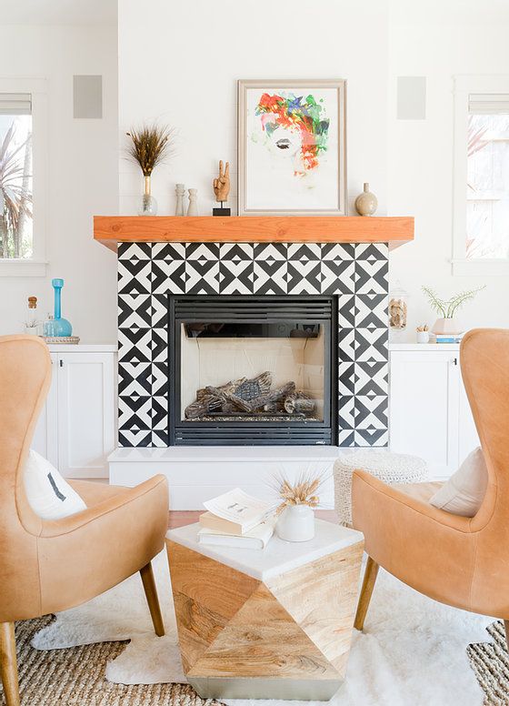 a fireplace with a black and white printed tile surround, a stained mantel, some decor is perfect for a mid-century modern living room
