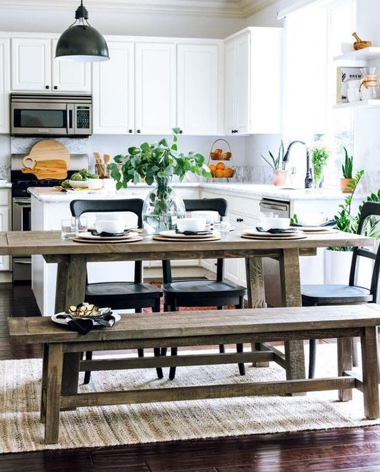 a fresh contemporary kitchen in white with a rustic dining zone with benches and touches of black for drama