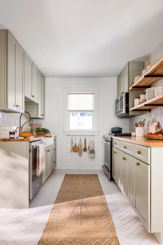 a grey farmhouse kitchen with a white herringbone floor, butcherblock countertops and open shelves plus a jute rug