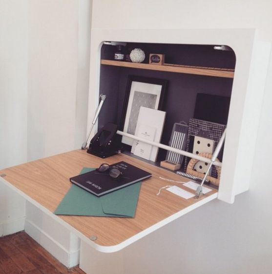 a minimalist white floating Murphy desk with curved angles and a plywood desktop features storage space and additional lights