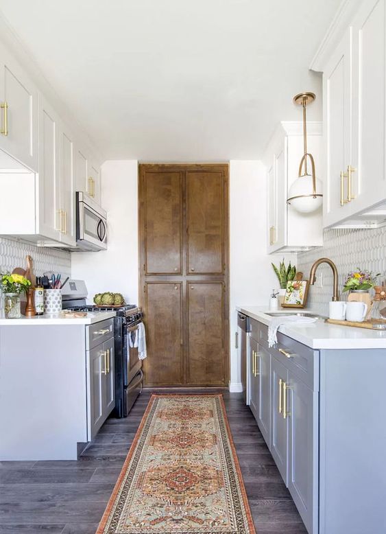 a modern farmhouse galley kitchen in blue with white countertops and gilded touches plus lights for a chic look